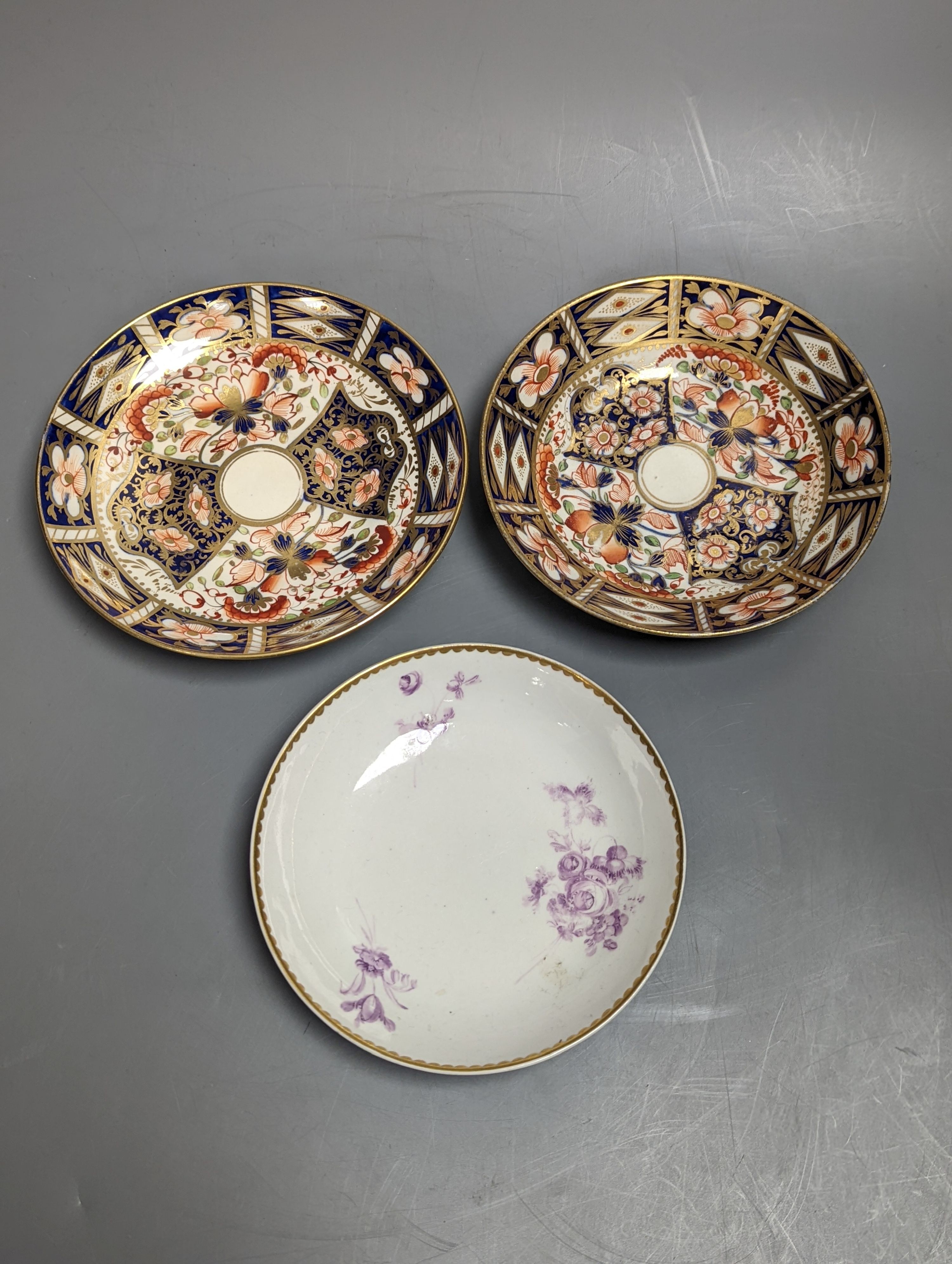 Two Derby imari pattern tea cups and saucers and a Derby teabowl and saucer painted in puce, each with three sprays of flowers, c.1785 and later